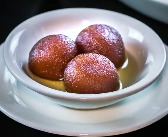 Gulab Jamun Waffle — Belgian waffle topped with syrup-infused donut holes and whipped cream at Sunny Side Up Sherwood Park