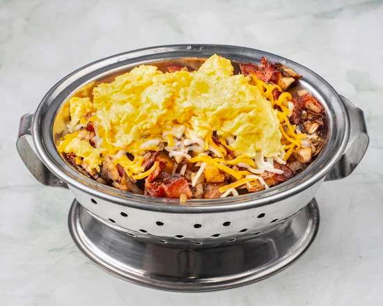 Sunrise Skillet — fluffy scrambled eggs, crispy bacon, grilled chicken and melted cheese over home fries at Sunny Side Up Sherwood Park